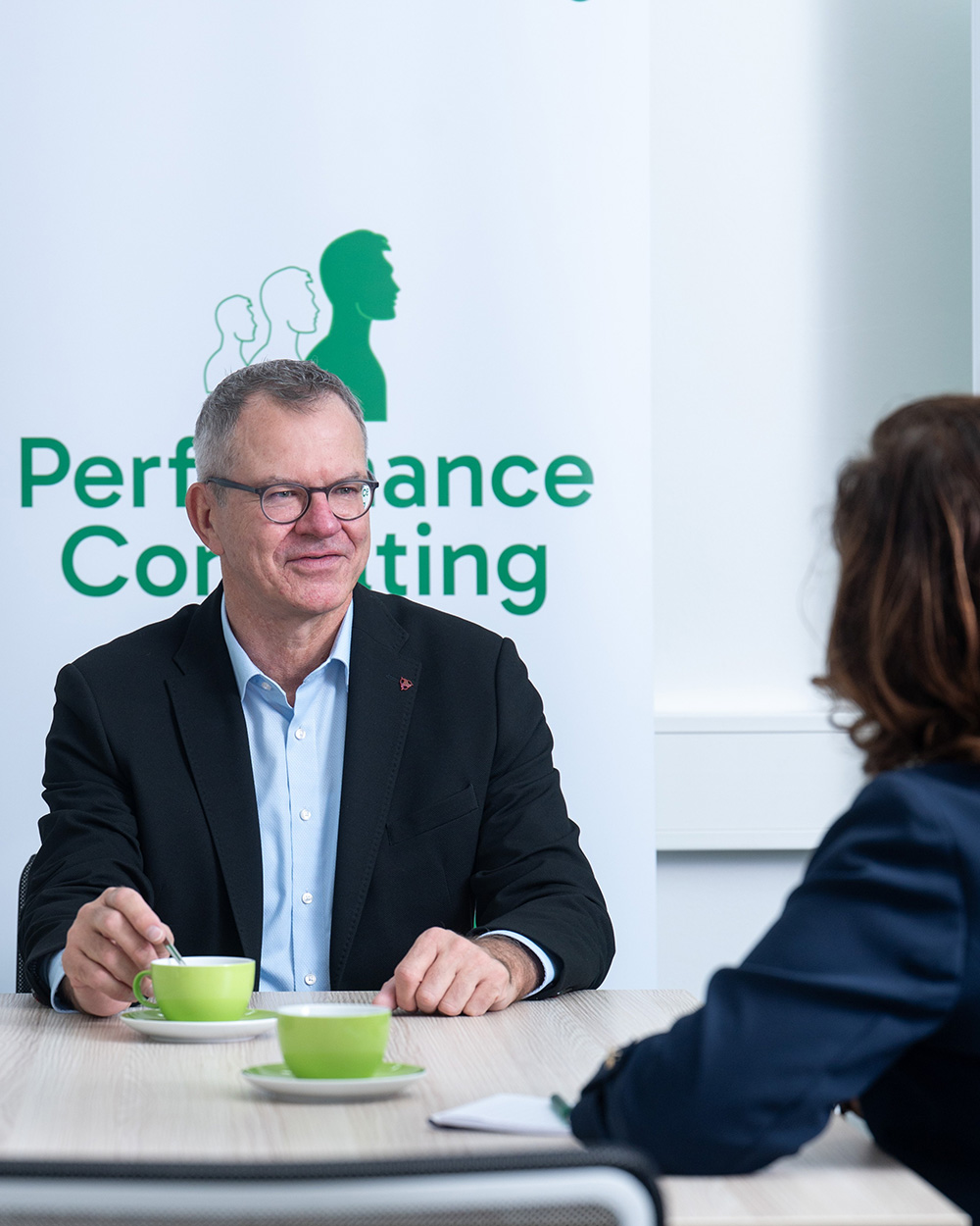 Jörg im Gespräch mit PCG-Logo im Hintergrund